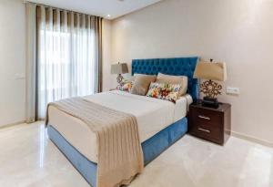 a bedroom with a large bed with a blue headboard at Large Comfort Duplex Casablanca Center in LʼOasis
