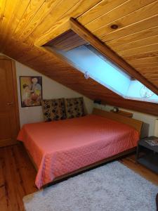 ein Schlafzimmer mit einem roten Bett auf dem Dachboden in der Unterkunft Studija viloje-Quiet Apartment 15 min from Airport in Kaunas + 14 Fotos