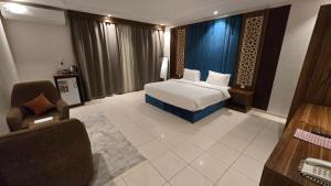 a bedroom with a bed and a chair and a desk at ابراج التاج للشق المخدومة جدة in Jeddah +50 photos