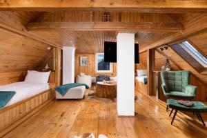 a bedroom with a bed and a living room at Valdora Forest Oasis - Spa Villa Fužine in Fužine