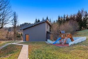 una piccola casa con scivolo e parco giochi di Valdora - Forest Oasis 