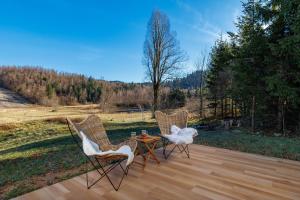 3 sedie e un tavolo su una terrazza di legno di Valdora - Forest Oasis  Altre 55 foto