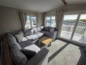 een woonkamer met een bank en een tafel bij Luxury 3 bed sleeps 8 caravan with sea view in Exmouth