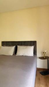 a bed with two white pillows and a table at Studio de standing à maarif in Maarif