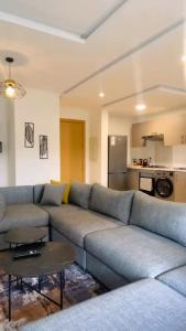 a living room with a blue couch and a kitchen at Studio de standing à maarif in Maarif