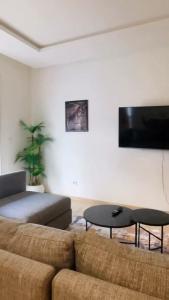 a living room with a couch and a flat screen tv at Studio de standing à maarif in Maarif