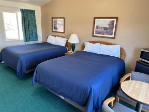 una camera d'albergo con due letti, un tavolo e delle sedie di Meadowcliff Lodge Coleville a Coleville Altre 54 foto