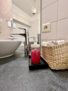 a bathroom with a sink and a glass of red liquid at Central Hub in Brussels