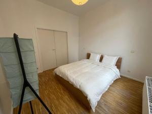 a bedroom with a large bed with white sheets at Central Hub in Brussels