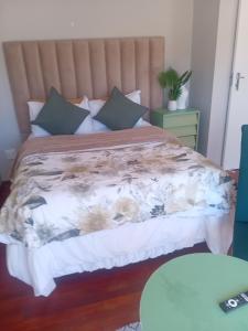 a bedroom with a bed with a floral bedspread at Oasis Simon's town cape town in Glencairn