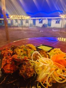 Mystic Resort Dublagadi في Balasore: طبق من الطعام مع اللحوم والخضروات على الطاولة