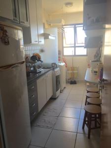 a kitchen with a refrigerator and a table and chairs at Apartamento Itapoan Vila Velha in Vila Velha