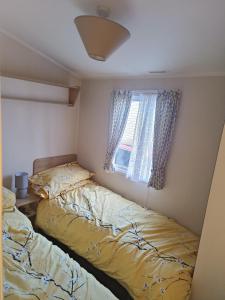 una camera da letto con due letti e una finestra di Ollys House a Prestatyn