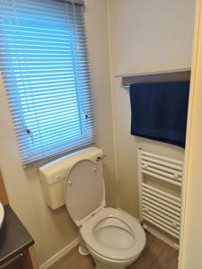 un bagno con un water e una finestra con un asciugamano blu di Ollys House a Prestatyn Altre 6 foto