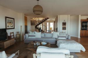 un soggiorno con un divano blu e una TV di Dune Rose Yzerfontein Villa a Yzerfontein