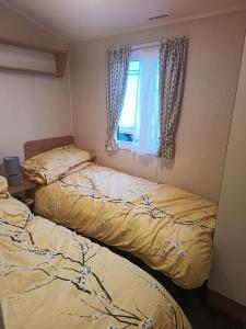 due letti in una stanza con finestra di Ollys House a Prestatyn