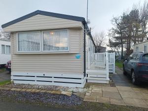 una piccola casa con una finestra e una macchina di Ollys House a Prestatyn