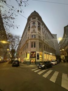 een hoog gebouw met auto's ervoor geparkeerd bij Apartments Old City Center in Wenen