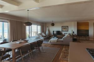 a living room with a dining table and a couch at Dune Rose Yzerfontein Villa in Yzerfontein