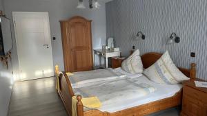 a bedroom with a large bed with a wooden frame at Weingut Günther und Gästezimmer in Gimbsheim +13 photos