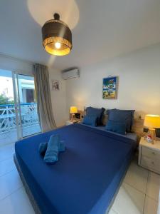 a bedroom with a large blue bed with blue pillows at Le Nid d'Amour Créole - Studio romantique avec accès au lagon et à la piscine XXL de 1 000 m2 - Saint-François in Saint-François +44 photos