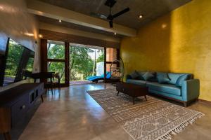 Una sala de estar con un sofá azul y una alfombra. en Roo Water Villas, en Balapitiya