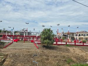 a park with a red fence and a palm tree at TRADEL Loreto in Iquitos