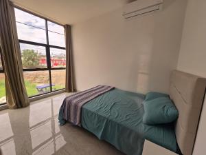 a bedroom with a bed and a large window at TRADEL Loreto in Iquitos