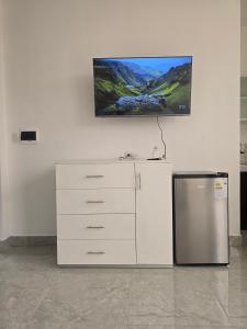 伊基托斯TRADEL Loreto的厨房配有冰箱,墙上挂有绘画作品