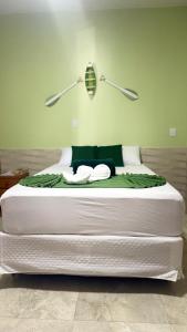 ein großes weißes Bett mit zwei Lampen darauf in der Unterkunft Pousada Banzeiro Marajó in Soure