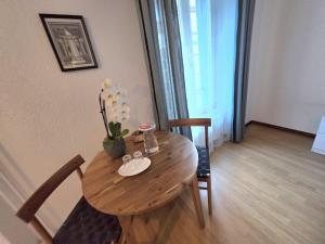 a wooden table with a vase of flowers on it at My Room Luzern in Lucerne