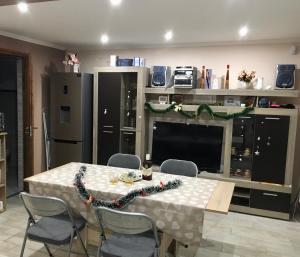 a kitchen with a table with chairs and a television at Fanni Vendégház in Mesteri +8 photos