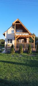 a house with a gambrel roof on top of a yard at Fanni Vendégház in Mesteri