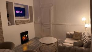 a living room with a couch and a fireplace at Suite 90m2 avec Jacuzzi jardin Proche Paris CDG in Livry-Gargan