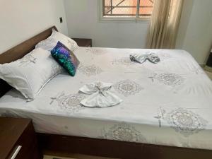 a bed with a white comforter and pillows on it at Le bon coin in Casablanca