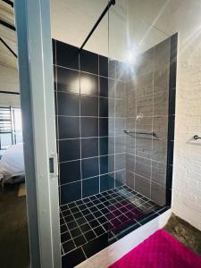 eine Dusche mit Glastür im Badezimmer in der Unterkunft Blue Haven on Craftmanship Hotel with WiFi Pool & Parking in Johannesburg