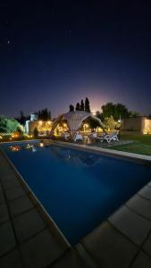 a swimming pool at night with a gazebo at casArtero eco posada in San Rafael