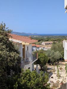 ein weißes Haus mit einem Balkon und Bäumen in der Unterkunft Sea view house, private parking, WiFi in Badesi