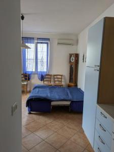 ein Schlafzimmer mit einem Bett und eine Küche mit einem Kühlschrank in der Unterkunft Sea view house, private parking, WiFi in Badesi