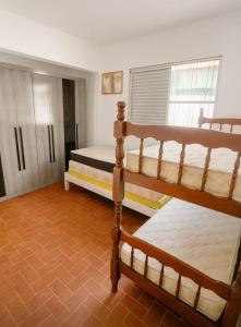 une chambre avec deux lits superposés dans une pièce dans l'établissement Casa Pé na Areia Centro de Mongaguá, à Mongaguá