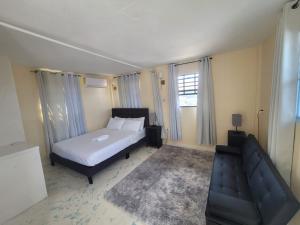 a small bedroom with a bed and a couch at Oceanview Suites in Saint Georgeʼs