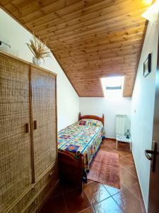 ein Schlafzimmer mit einem Bett und einer Holzdecke in der Unterkunft Casa Zuzu in Ovindoli