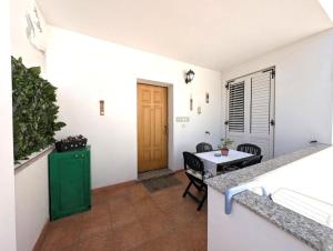 Zimmer mit Tür, Tisch und Stühlen in der Unterkunft Sea view house, private parking, WiFi in Badesi + 20 Fotos