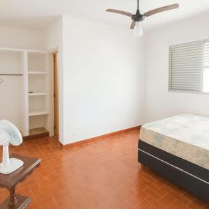 une chambre avec un lit et un ventilateur de plafond dans l'établissement Casa Pé na Areia Centro de Mongaguá, à Mongaguá 3 autres photos