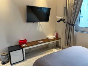 a room with a tv on a wall with a bed at 하늘정원 in Gwangju
