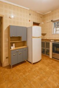 une cuisine avec un réfrigérateur blanc dans une pièce dans l'établissement Casa Pé na Areia Centro de Mongaguá, à Mongaguá