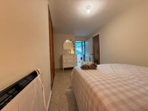 een slaapkamer met een bed met een ladekast en een spiegel bij A Casiña de Coles in Gustey