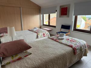 a hotel room with two beds and a chair at 3 Marias São Sebastião in Lousa