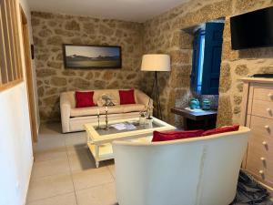 a living room with a couch and a table at 3 Marias São Sebastião in Lousa
