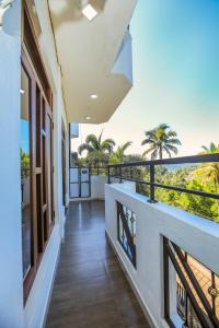 balcón con vistas al océano y a las palmeras en SaRu Holiday Apartments - 2BR 6 Guests, en Kandy